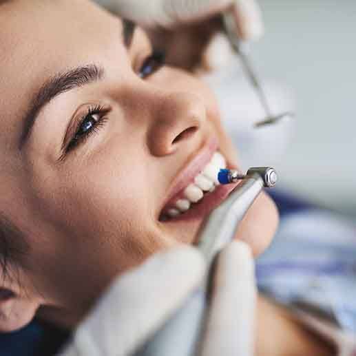 a woman having her teeth cleaned by a dental hygienist