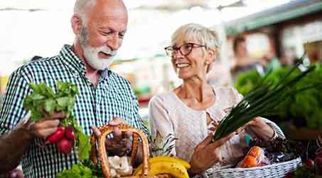 a couple buying groceries at a farmer’s market