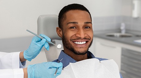 Smiling male patient in dental treatment chair