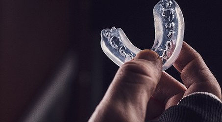 Patient holding clear mouthguard
